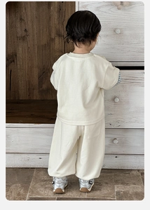 Detailed back view of toddler cream sweatshirt and pants set with checkered sleeve details