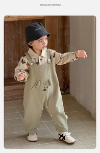 Close-up of baby boy outfit with cartoon puppy overalls and duck print shirt