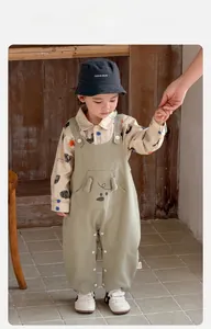 Detail of baby boy cotton set with bear face pocket overalls and printed shirt