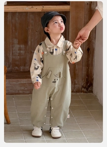 Detail of baby boy cotton set showing cartoon bird shirt and dog embroidery overalls