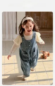 Detail of toddler girl polka dot denim overalls with ruffle sleeve base layer set