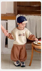 Detailed close-up of cream and brown cotton sweatshirt set with guinea pig graphic for boys