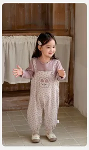 Detail of baby girl floral overalls with cute bunny embroidery and lilac long sleeve shirt