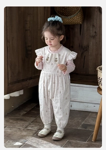 Close-up of baby girl ruffle collar bodysuit with cute bear print and frill detail