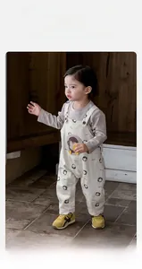 Detail of toddler penguin pattern overalls with grey long sleeve undershirt for boys
