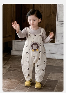 Detail of baby cotton romper set with penguin embroidery and printed pattern