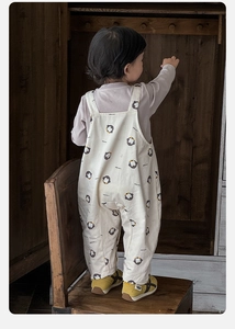 Detail of toddler penguin print overalls and lavender base shirt with elastic cuffs
