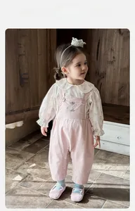 Detail of floral long-sleeve blouse and pink overall with rabbit embroidery for baby girl