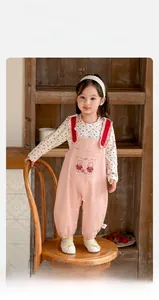 Détail de la salopette rose pour fille avec poche lapin et haut à fleurs blanches