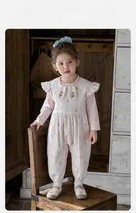 Detail of baby girl floral romper with ruffle collar and teddy bear print detail