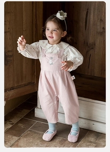 Close-up of floral embroidery and pearl details on pink suspender pants with floral shirt