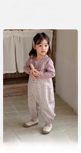 Detail of baby girl floral overalls with cute rabbit embroidery and ruffled cotton shirt