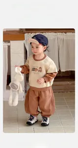 Detail of baby boy two-piece casual set featuring khaki cartoon sweatshirt and loose pants