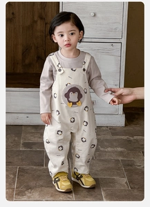 Detail of penguin embroidery on cream baby overalls with soft cotton knit texture