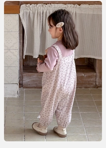 Detail of baby girl floral overalls and purple long sleeve shirt with ruffle trim