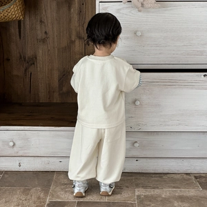 Back view of toddler casual two-piece outfit with cream sweatshirt and wide-leg knit pants