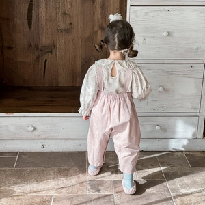Floral Peter Pan collar shirt and pink overalls set for toddler girls in cozy indoor setting