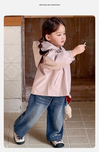 Detail of embroidered forest pattern on navy blue wide-leg jeans for toddler girls