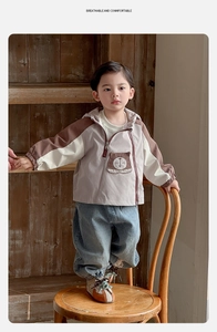Dettaglio della giacca a vento da bambino con tasca a orsetto e design patchwork
