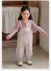 Detailed view of baby girl outfit with purple rabbit embroidery on floral overalls