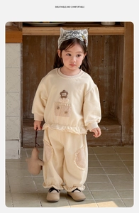 Detail of toddler cotton sweatshirt set with brown flower patch and plaid pocket detail