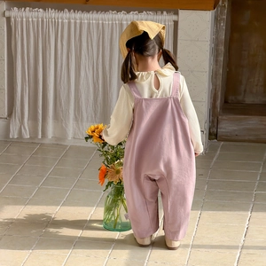 Tenue de printemps fille avec chemise à volants crème, salopette rose et chapeau assorti