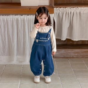 Tenue fille avec salopette en denim bleu et haut beige à manches longues et volants