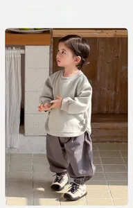 Detail view of cotton baby sweatshirt with cartoon bear print and grey jogger pants
