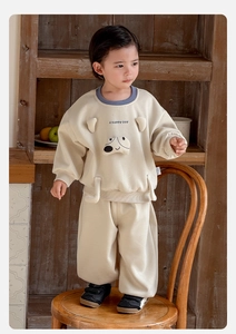 Detail of baby boy's oatmeal tracksuit with cartoon dog and contrast blue neckline