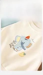 Détail du sweat-shirt ivoire pour bébé avec motif éléphant et col rond côtelé