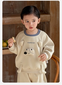 Close-up of baby boy cartoon sweatshirt set with rib-knit collar and fabric label detail