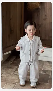 Detailed look at toddler three-piece outfit with grey vest, plaid shirt and casual pants