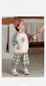 Détail d'un ensemble de printemps pour bébé avec sweat color-block et broderie éléphant