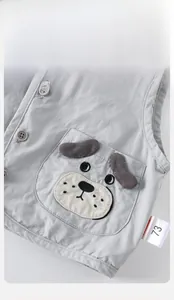 Detailed view of grey baby vest featuring a cute cartoon puppy patch and button front closure