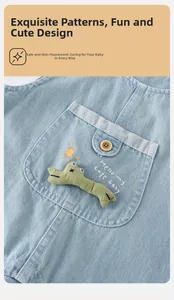Detail of baby denim overalls with 3D crocodile decor and sun embroidery on chest pocket