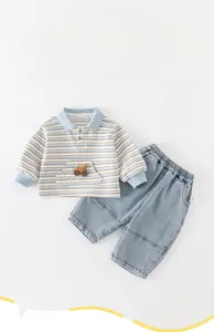 Detail of baby boy striped polo shirt and denim pants set with cute car embroidery