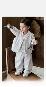 Detail of baby boy three-piece suit with grey vest, plaid shirt and trousers