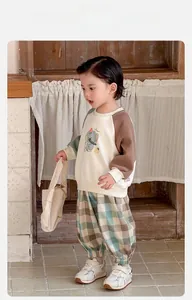 Détail du sweat-shirt bébé à motif éléphant et pantalon en tricot à carreaux