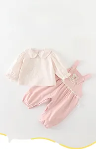 Detailed view of baby girl floral shirt and pink overall set with size 73 label tag