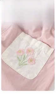 Detailed close-up of pink floral embroidery on a baby girl's soft cotton shirt pocket