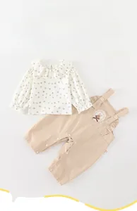 Dettaglio completo neonata con camicia a cuori e salopette con pizzo a coniglietto