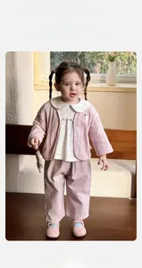 Detail von Baby-Mädchen-Blumenshirt mit rosa Strickjacke und Hose als 3-teiliges Set