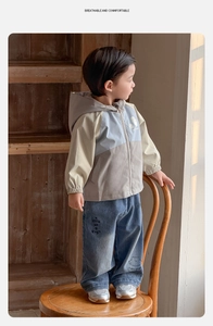 Détail de la veste à capuche color-block avec motifs et jean assorti pour petit garçon