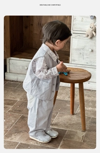 Detail view of baby boy three-piece suit with vest, plaid shirt and trousers in retro style