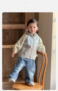 Détail d'un ensemble veste à capuche pour bébé avec broderie et pantalon en jean