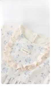 Detailed view of baby girl floral top with lace trim collar and handmade label
