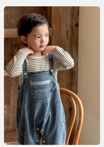 Détail de l'ensemble haut rayé et salopette en jean pour bébé avec broderie café