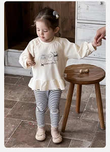 Detail of baby girl ruffled sweatshirt with animal print and striped leggings