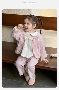 Detail der rosa Strickjacke und Blumenhemd für Babys in einer süßen Außenumgebung