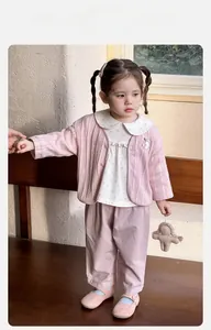 Detailaufnahme der rosa Strickjacke für Mädchen mit Blumenkragenhemd und Stoffhose